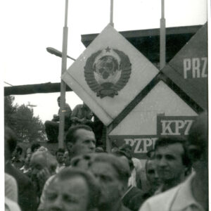 tłum ludzi stojących na tle instalacji propagandowej