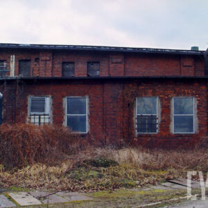 fragment niskiej ceglanej hali z oknami