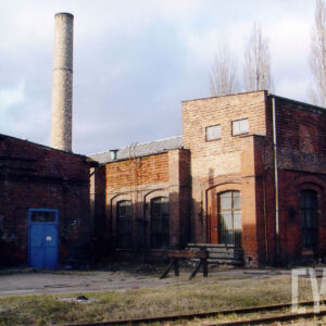 ceglane, niskie budynki warsztatowe, w głębi ceglany, wysoki komin