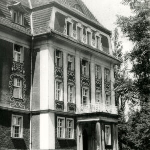 trzykondygnacyjny budynek z zaadoptowanym poddaszem z bogato zdobioną elewacją