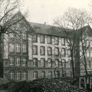 trzypiętrowy budynek z bogato zdobioną elewacją i bocznymi ryzalitami