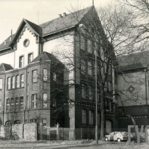 trzypiętrowy budynek z bogato zdobioną elewacją i bocznymi ryzalitami