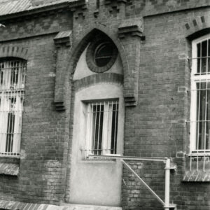 fragment elewacji z oknami i bogatą dekoracją architektoniczną nad oknem