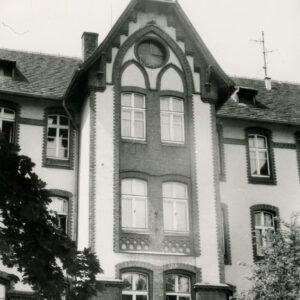 fragment elewacji budynku z trójkątnym szczytem i dekoracją architektoniczną