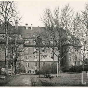 trzypiętrowy budynek, przed budynkiem drzewa i teren zielony