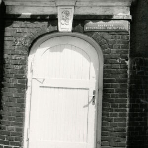 drewniane drzwi nad nimi dekoracja rzeźbiarska