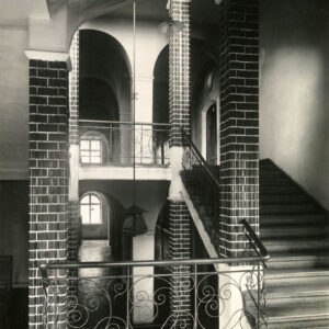 kamienne schody z ceglanymi kolumnami i ozdobną metalową balustradą