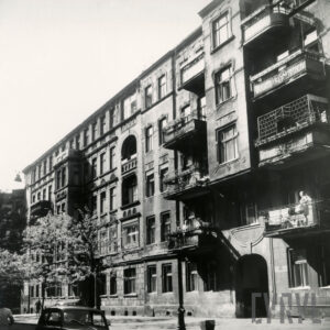 kilkukondygnacyjne kamienice z balkonami i wykuszami, przed nimi drzewa