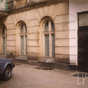 fragment przyziemia kamienicy z dużymi półokrągło zakończonymi oknami