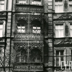 fragment elewacji kamienicy z bogato zdobionymi balkonami z elementami metalowymi