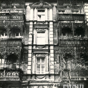 fragment elewacji kamienicy z bogato zdobionymi balkonami z elementami metalowymi