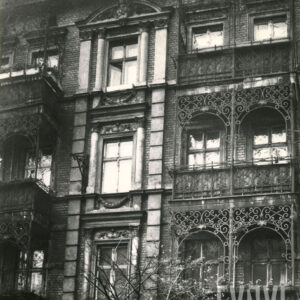 fragment elewacji kamienicy z bogato zdobionymi balkonami z elementami metalowymi