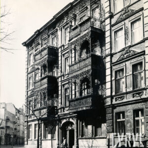 czterokondygnacyjna kamienica z bogato zdobionymi balkonami z elementami metalowymi