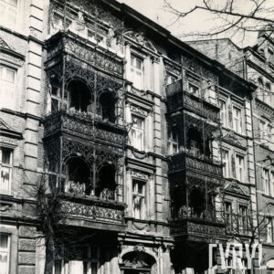 kilkukondygnacyjna kamienica z bogato zdobionymi balkonami z elementami metalowymi