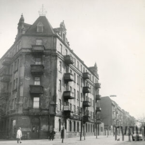 kilkukondygnacyjna kamienica narożna z balkonami i ozdobnymi szczytami