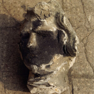 zniszczona kamienna głowa leżąca na posadzce