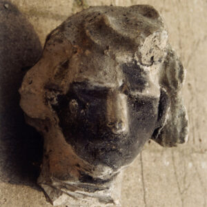 zniszczona kamienna głowa leżąca na posadzce