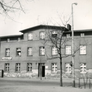 trzykondygnacyjny budynek, przed nim drzewo pozbawione liści, obok betonowa latarnia