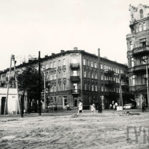 skrzyżowanie ulic, na pierwszym planie pusty plac, w głębi kilkukondygnacyjne kamienice, z lewej parterowy budynek