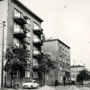 kilkukondygnacyjne budynki mieszkalne, z lewej budynek z balkonami, przed nimi drzewa, z prawej tramwaj, u dołu zdjęcia małe kopczyki kamieni