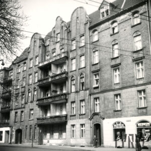 czteropiętrowa kamienica z zamieszkałym poddaszem i ozdobnymi szczytami