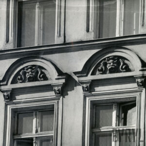 fragment elewacji z oknami, nad nimi dekoracja rzeźbiarska