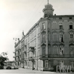 przy chodniku dwie, kilkukondygnacyjne kamienice, na pierwszym planie kamienica narożna z narożnikiem nakrytym hełmem