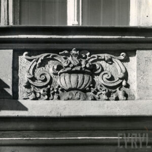 dekoracja rzeźbiarska o motywach roślinnych pod oknem kamienicy