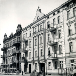 trzypiętrowe kamienice z balkonami i dekoracją rzeźbiarską elewacji, przy kamienicy z lewej rozstawiano rusztowania