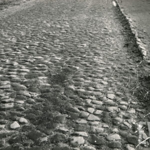 fragment brukowanej ulicy z gruntowym poboczem