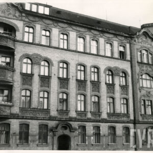 trzypiętrowa narożna kamienica z bogato zdobioną elewacją, z lewej balkony