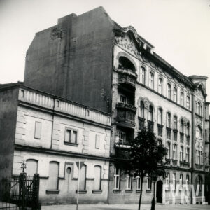 trzypiętrowa narożna kamienica z bogato zdobioną elewacją, z lewej dobudowana do niej dwukondygnacyjna dobudówka