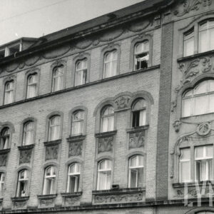 fragment elewacji trzypiętrowej kamienicy z dekoracją rzeźbiarską