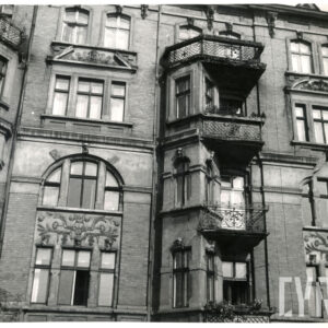 fragment elewacji czteropiętrowej kamienicy z bogato zdobioną elewacją i balkonami