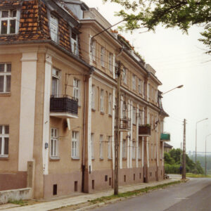 dwupiętrowy budynek mieszkalny z piwnicą, mansardowym dachem i balkonami