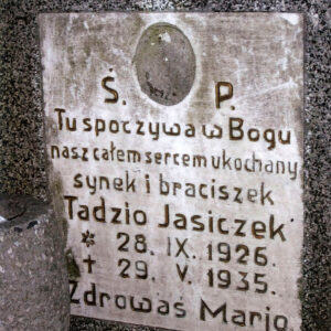 Biała prostokątna tablica z napisami. Ślad po medalionie portretowym. Fragment kamiennego wazonu.