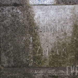 Dobrze zachowana pozioma kamienna tablica w kształcie prostokąta z napisami. Częściowo pokryta mchem.