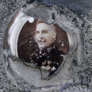 Mocno zniszczony medalion portretowy przedstawiający mężczyznę w mundurze z orderami w klapie.