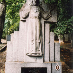 Duża płyta nagrobna z płaskorzeźbą Chrystusa Miłosiernego. Do podstawy umocowana jest czarna tablica z inskrypcją. Po jej prawej stronie znajduje się medalion portretowy. 