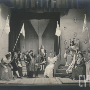 scena zbiorowa w pałacu, na tronie siedzi królowa w długiej sukni i koronie, obok siedzi kobieta w białej sukni i koronie, przed nią przyklęka mężczyzna z lutnią w ręce, po obu stronach elegancko ubrani ludzie, z których niektórzy stoją a inni kłaniają się 