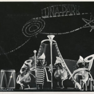 na scenie cztery kukiełki z instrumentami i hełmach na głowie, za nimi dekoracja z napisem lunapark