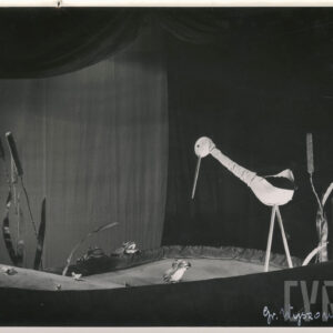 scenografia przedstawia staw, w środku dwie kukiełki żaba i bocian, przy brzegu dwie żaby