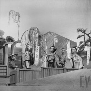 scena przy drewnianym płotku, obok siebie stoi pięć lalek w różnych pozach z lampionami w rękach, po lewej stronie z domku wychodzi lalka w chińskim kapeluszu, z tyłu drzewa i góra 