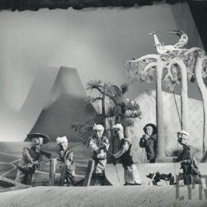 cztery lalki stoją obok siebie z siekierami w rękach, z prawej strony stoją trzy lalki w różnych pozach, z tyłu za jednym z drzew siedzi okazały ptak