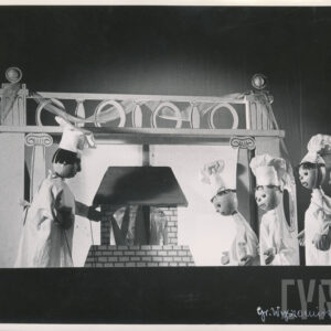 przy dekoracji przedstawiającej piec stoi lalka w stroju kucharza, po drugiej stronie znajdują się cztery lalki w strojach kucharzy