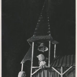 na scenie znajdują się dwie lalki w długich białych sukniach ze skrzydłami na plecach, jedna siedzi pod dzwonem, na belce kościelnej wieży, druga stoi obok