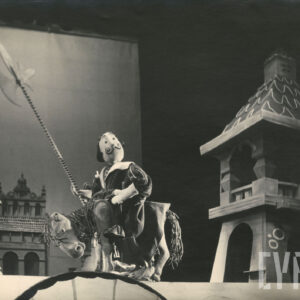 kukła przedstawiającą konia, na której siedzi lalka z zakręconymi wąsami i halabardą w prawej ręce, obok wieża