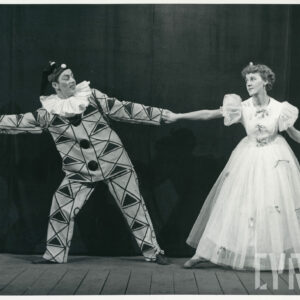 kobieta w długiej sukni z kokardkami i mężczyzna w stroju pajaca trzymają się za ręce