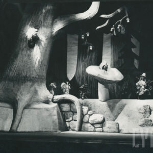 scena w lesie, pomiędzy drzewami obok siebie stoją trzy lalki - wiewiórka, jeż i mysz, obok na grzybku siedzi lalka przedstawiająca ślimaka, po lewej stronie lalka z długimi włosami w wiklinowym kapeluszu