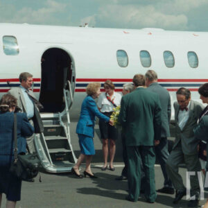 liczna grupa osób stojąca na tle samolotu